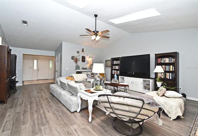 26 Canter Club Ct, Debary, FL 32713 - living room featuring vaulted ceiling, wood finished floors, a ceiling fan, a skylight, and a textured ceiling