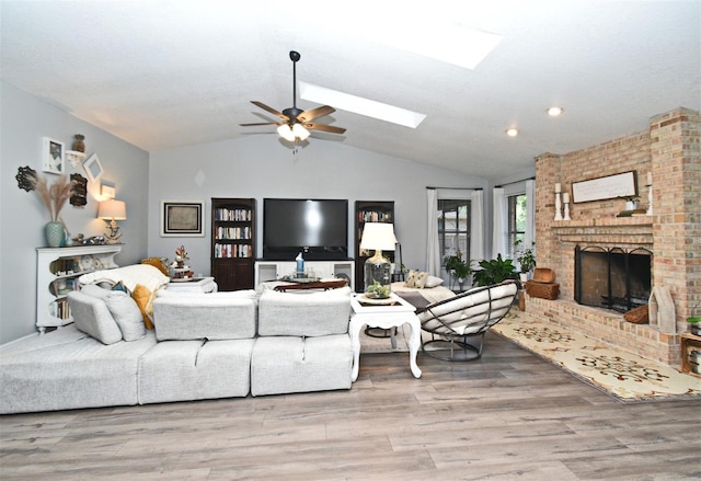26 Canter Club Ct, Debary, FL 32713 - living room featuring vaulted ceiling, a fireplace, wood finished floors, a ceiling fan, and a skylight