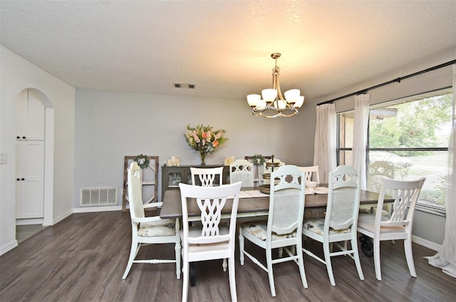 26 Canter Club Ct, Debary, FL 32713 - dining area featuring a chandelier, wood finished floors, a textured ceiling, and arched walkways