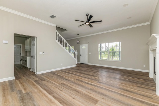 1660 Justin Matthew Way, Saint Cloud, FL 34771 - unfurnished living room featuring a ceiling fan, crown molding, stairs, wood finished floors, and a fireplace