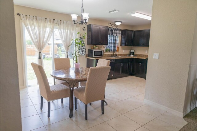 16863 SW 29th Terrace Rd, Ocala, FL 34473 - dining area with a chandelier, a textured wall, and light tile patterned flooring