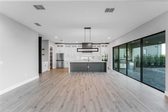 15942 Vetta Dr, Bella Collina, FL 34756 - unfurnished living room featuring light wood-style floors and a sink