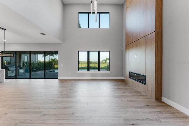 15942 Vetta Dr, Bella Collina, FL 34756 - unfurnished living room featuring a high ceiling and light wood-style flooring