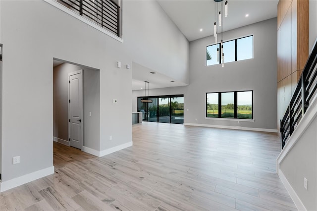 15942 Vetta Dr, Bella Collina, FL 34756 - unfurnished living room with plenty of natural light, a towering ceiling, and light wood finished floors