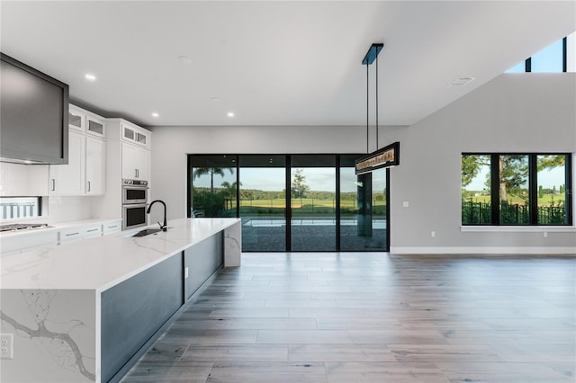 15942 Vetta Dr, Bella Collina, FL 34756 - kitchen with open floor plan, plenty of natural light, light wood-style floors, a kitchen island with sink, and recessed lighting