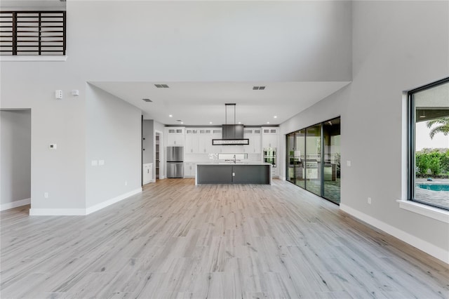 15942 Vetta Dr, Bella Collina, FL 34756 - unfurnished living room featuring a high ceiling, light wood-type flooring, and recessed lighting