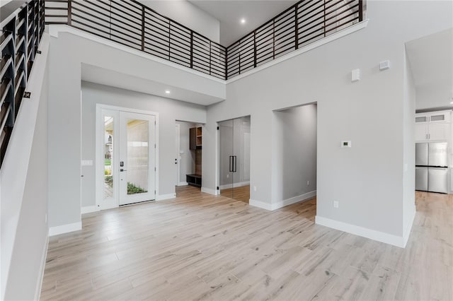 15942 Vetta Dr, Bella Collina, FL 34756 - unfurnished living room with a towering ceiling, light wood-type flooring, and recessed lighting