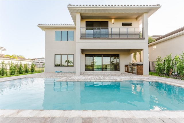15942 Vetta Dr, Bella Collina, FL 34756 - rear view of property with an outdoor kitchen, a balcony, and stucco siding