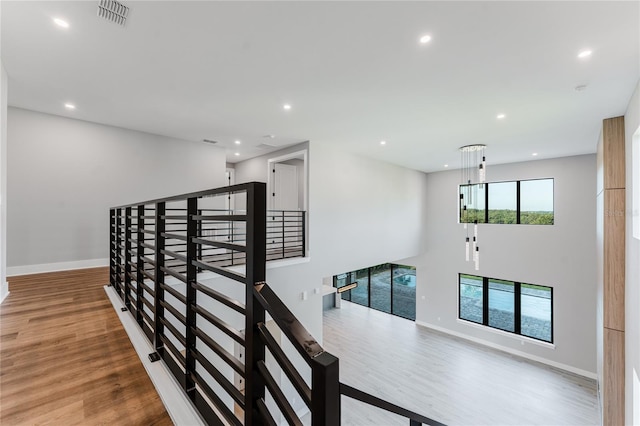 15942 Vetta Dr, Bella Collina, FL 34756 - hallway with wood finished floors, recessed lighting, and an upstairs landing