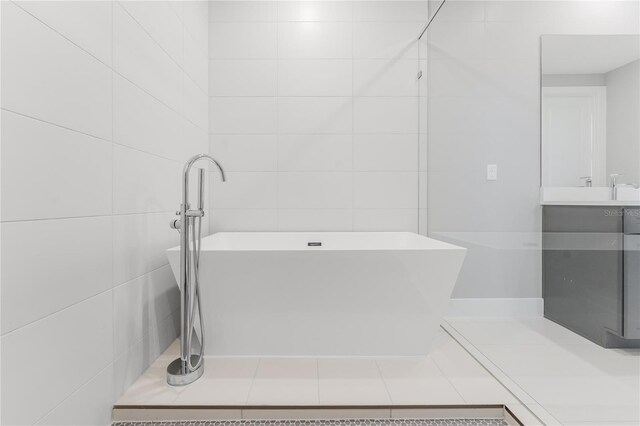 15942 Vetta Dr, Bella Collina, FL 34756 - bathroom featuring a soaking tub, vanity, and tile walls