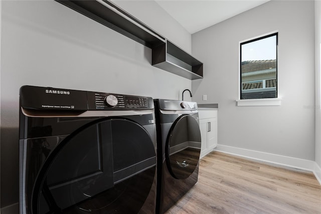 15942 Vetta Dr, Bella Collina, FL 34756 - laundry room with washer and dryer, light wood finished floors, and cabinet space