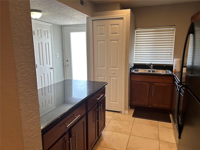 1922 Conway Rd Unit 1922, Orlando, FL 32812 - kitchen with light tile patterned floors, freestanding refrigerator, a textured ceiling, and dark stone counters