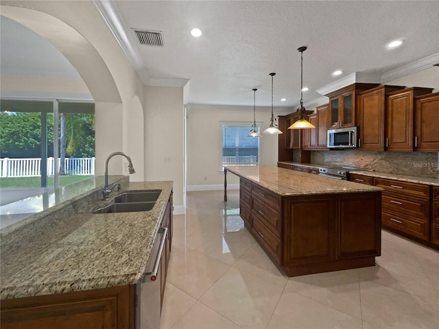 11356 Callaway Pond Dr, Riverview, FL 33579 - kitchen featuring appliances with stainless steel finishes, a spacious island, tasteful backsplash, recessed lighting, and arched walkways