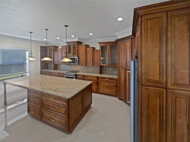 11356 Callaway Pond Dr, Riverview, FL 33579 - kitchen with brown cabinetry, appliances with stainless steel finishes, backsplash, light stone counters, and a kitchen island