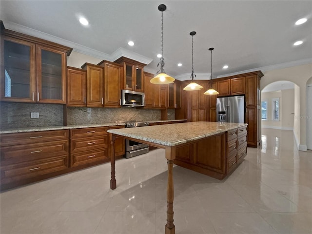11356 Callaway Pond Dr, Riverview, FL 33579 - kitchen with appliances with stainless steel finishes, arched walkways, brown cabinetry, ornamental molding, and decorative backsplash
