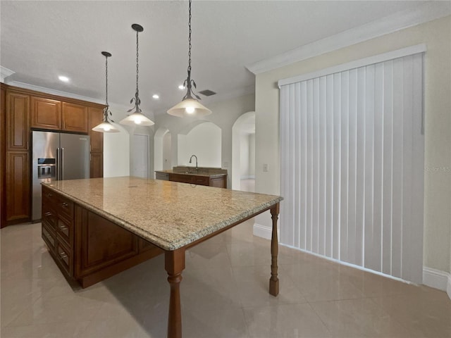 11356 Callaway Pond Dr, Riverview, FL 33579 - kitchen featuring high end fridge, arched walkways, a center island, light stone counters, and ornamental molding