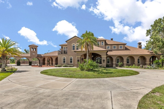 9400 Laws Rd, Clermont, FL 34714 - mediterranean / spanish home featuring curved driveway, stucco siding, a front yard, and a chimney