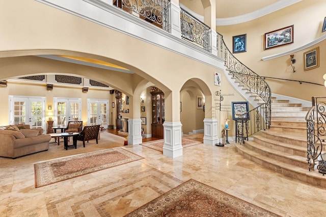 9400 Laws Rd, Clermont, FL 34714 - foyer entrance featuring a high ceiling, arched walkways, marble tiled flooring, stairs, and french doors