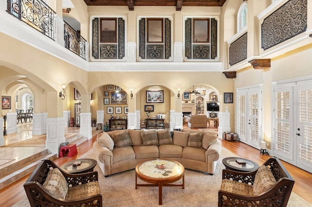 9400 Laws Rd, Clermont, FL 34714 - living area with a towering ceiling, arched walkways, ornate columns, wood finished floors, and french doors