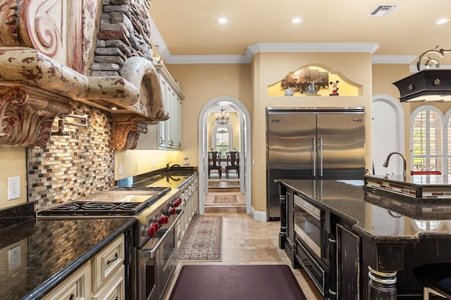 9400 Laws Rd, Clermont, FL 34714 - kitchen featuring built in appliances, ornamental molding, dark stone counters, recessed lighting, and plenty of natural light