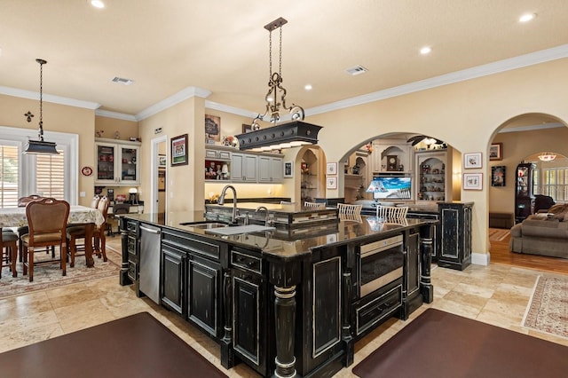 9400 Laws Rd, Clermont, FL 34714 - kitchen featuring dark cabinets, appliances with stainless steel finishes, a large island, arched walkways, and open floor plan