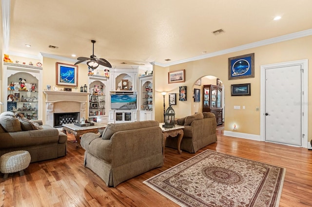 9400 Laws Rd, Clermont, FL 34714 - living area featuring arched walkways, a ceiling fan, crown molding, wood finished floors, and a fireplace