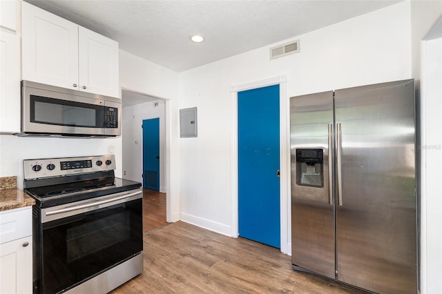 131 N Central Ave, Apopka, FL 32703 - kitchen featuring appliances with stainless steel finishes, electric panel, light wood-type flooring, white cabinets, and recessed lighting