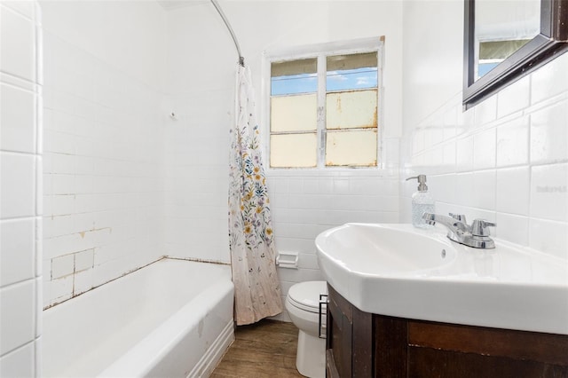 131 N Central Ave, Apopka, FL 32703 - full bathroom featuring tile walls, wood finished floors, vanity, and shower / tub combo with curtain