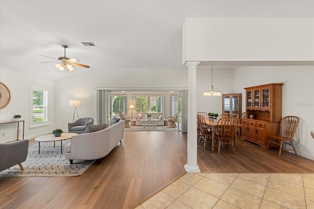 1254 Spartanburg Way, The Villages, FL 32162 - living area with decorative columns, vaulted ceiling, light wood-style floors, ceiling fan, and a chandelier