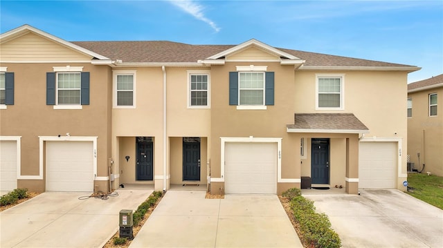 200 Feltrim Reserve Blvd, Davenport, FL 33837 - townhome / multi-family property featuring stucco siding, driveway, a shingled roof, and an attached garage