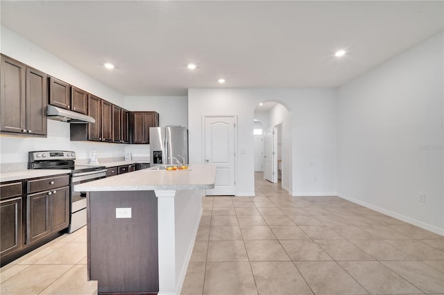 200 Feltrim Reserve Blvd, Davenport, FL 33837 - kitchen with stainless steel appliances, under cabinet range hood, arched walkways, light countertops, and a center island with sink