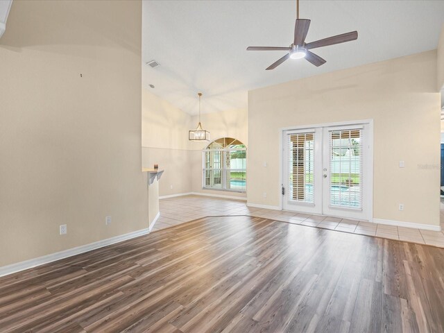 14322 Pine Cone Trl, Clermont, FL 34711 - unfurnished living room featuring wood finished floors, french doors, a ceiling fan, and a chandelier