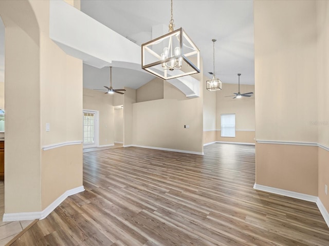 14322 Pine Cone Trl, Clermont, FL 34711 - unfurnished dining area with ceiling fan, healthy amount of natural light, high vaulted ceiling, and wood finished floors