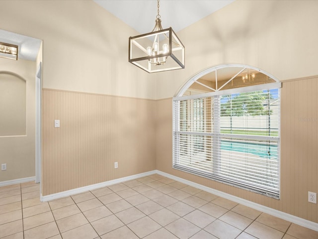 14322 Pine Cone Trl, Clermont, FL 34711 - unfurnished dining area with a chandelier, light tile patterned floors, and a wainscoted wall