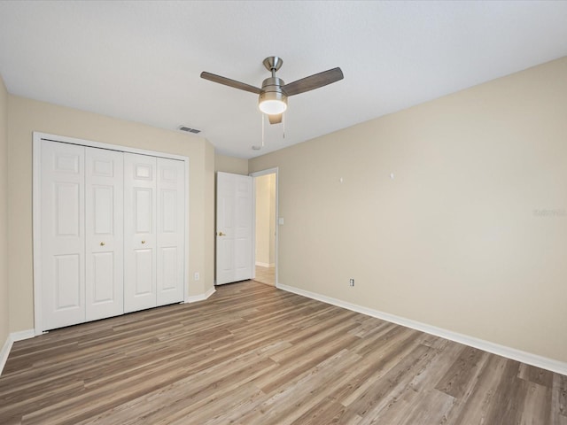 14322 Pine Cone Trl, Clermont, FL 34711 - unfurnished bedroom with light wood-style flooring, a closet, and a ceiling fan