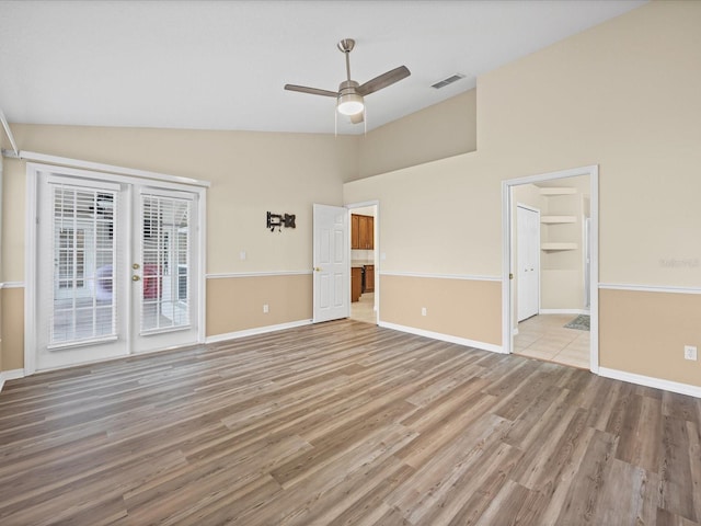 14322 Pine Cone Trl, Clermont, FL 34711 - spare room with light wood-style floors, ceiling fan, french doors, and high vaulted ceiling