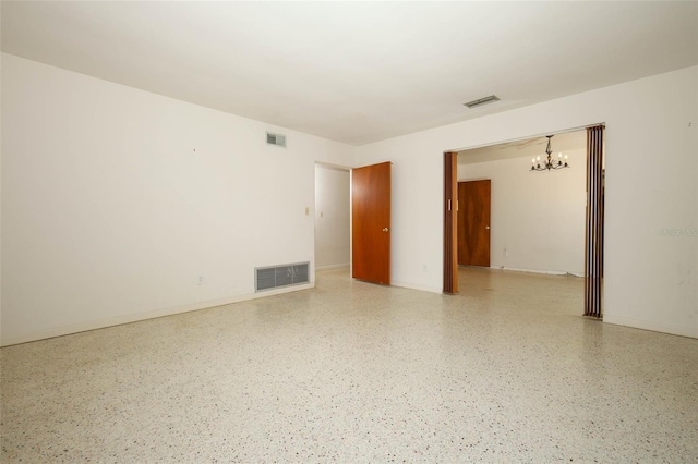 2417 Bayfront Pkwy, Orlando, FL 32806 - spare room with a chandelier and dark speckled floor