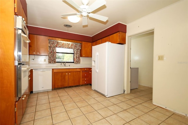 2417 Bayfront Pkwy, Orlando, FL 32806 - kitchen with white appliances, a ceiling fan, light countertops, brown cabinets, and light tile patterned flooring
