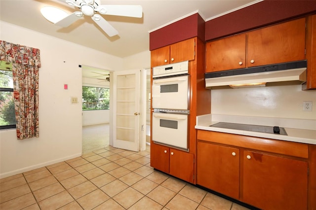 2417 Bayfront Pkwy, Orlando, FL 32806 - kitchen with white double oven, under cabinet range hood, a ceiling fan, black electric cooktop, and light countertops