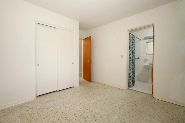 2417 Bayfront Pkwy, Orlando, FL 32806 - unfurnished bedroom featuring a closet, connected bathroom, and speckled floor