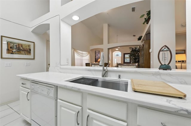 1752 Challenger Ave, Davenport, FL 33897 - kitchen featuring white dishwasher, arched walkways, high vaulted ceiling, white cabinets, and light tile patterned floors