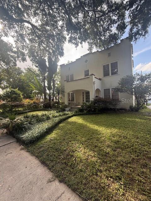 501 Richmond St, Orlando, FL 32806 - back of house featuring stucco siding and a yard