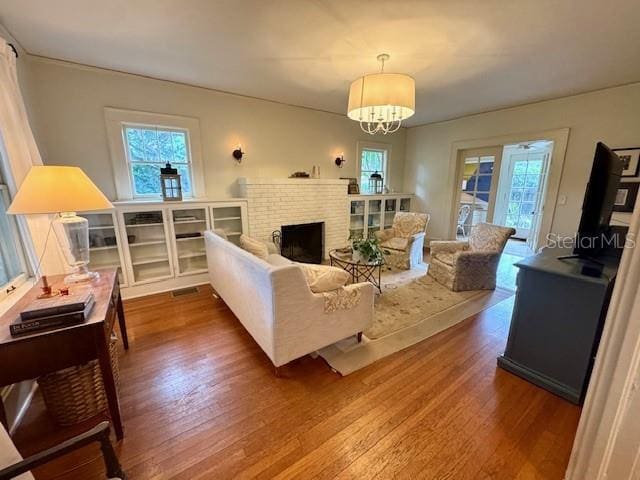 501 Richmond St, Orlando, FL 32806 - living room featuring wood finished floors, a fireplace, and a chandelier