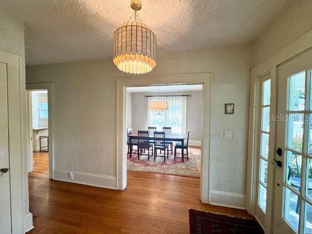501 Richmond St, Orlando, FL 32806 - dining room with a textured wall, a textured ceiling, wood finished floors, healthy amount of natural light, and a chandelier