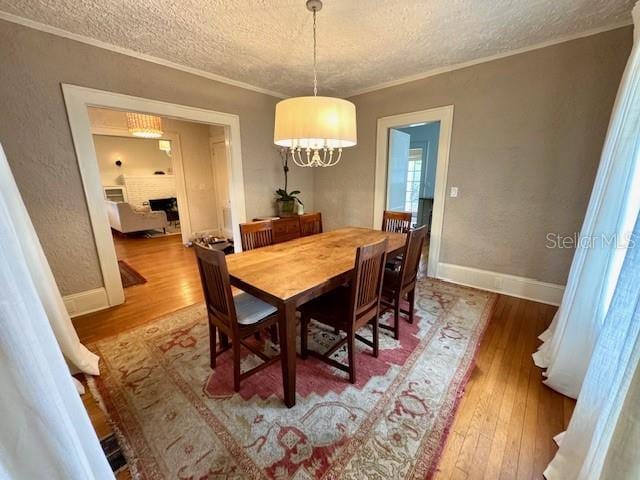 501 Richmond St, Orlando, FL 32806 - dining room featuring a textured ceiling, hardwood / wood-style floors, crown molding, and a chandelier