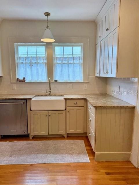 501 Richmond St, Orlando, FL 32806 - kitchen with stainless steel dishwasher, light wood finished floors, light countertops, and tasteful backsplash