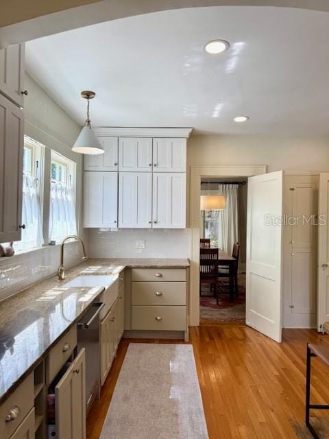 501 Richmond St, Orlando, FL 32806 - kitchen featuring stainless steel dishwasher, light stone counters, light wood finished floors, decorative light fixtures, and recessed lighting