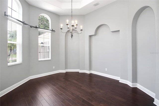 1441 Foxtail Ct, Lake Mary, FL 32746 - spare room with dark wood-style flooring, a chandelier, a raised ceiling, arched walkways, and a towering ceiling