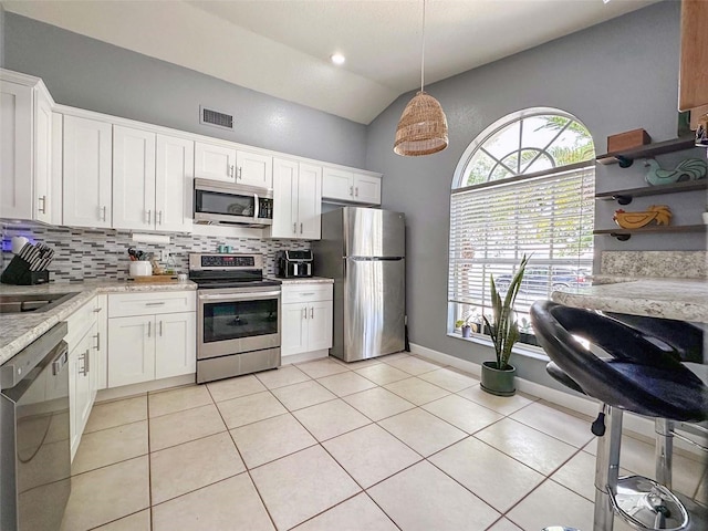 1470 Daniels Cove Dr, Winter Garden, FL 34787 - kitchen with stainless steel appliances, decorative backsplash, light tile patterned flooring, white cabinets, and lofted ceiling