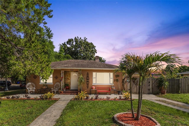 1104 W Marjorie St, Lakeland, FL 33815 - view of front facade with stucco siding, covered porch, and a chimney